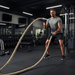 Man exercising with battle ropes in a gym setting from ropethe.com