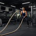 Woman exercising with battle ropes in a gym setting from ropethe.com